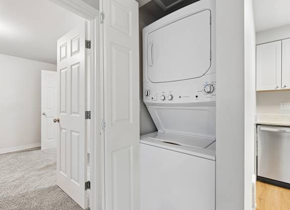 A white oven and microwave are built into a kitchen cabinet.