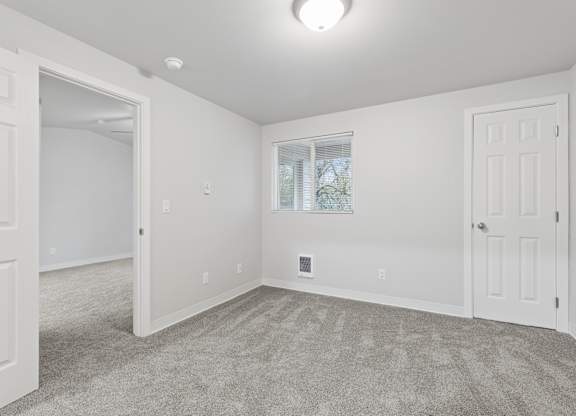 A room with white walls and a carpeted floor.