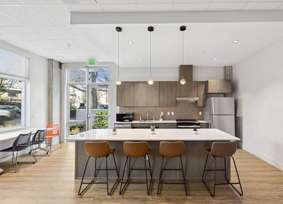 A modern kitchen with a bar area and chairs.