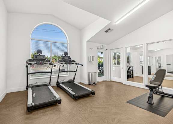 A room with treadmills and a stationary bike.