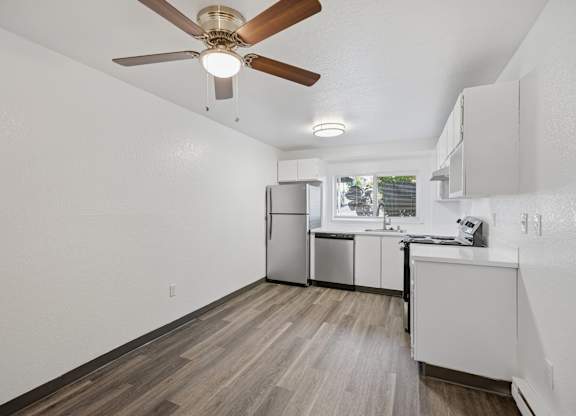 A kitchen with a refrigerator, sink, and cabinets.