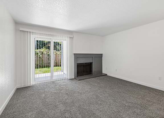 A room with a fireplace and sliding glass doors.