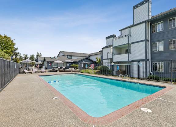 A swimming pool surrounded by a fence and buildings.