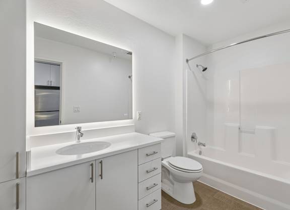 A white bathroom with a toilet, sink, and bathtub.