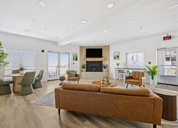 A living room with a brown sofa and green chairs.