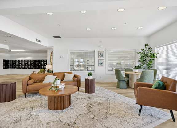 A living room with a brown sofa, a brown coffee table, and a green armchair.