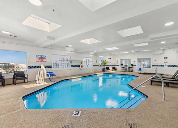 A large indoor swimming pool with lounge chairs and a sign that reads "USN HOTEL".