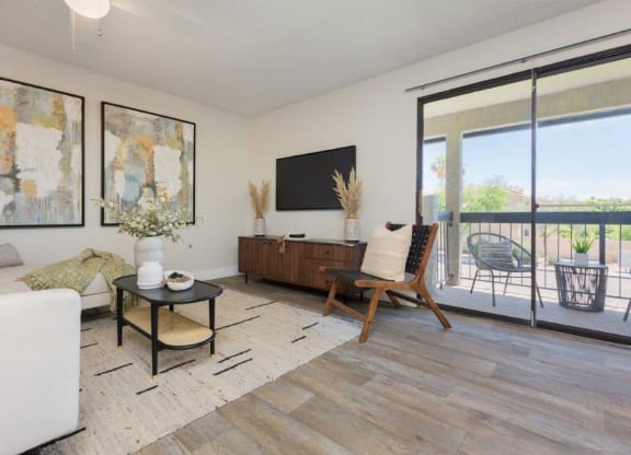 a living room with a couch and a tv and a balcony