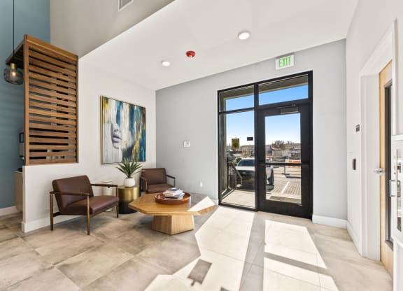 a living room with a table and chairs and a door to a balcony