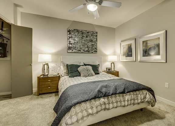 A bedroom with a large bed and a ceiling fan.