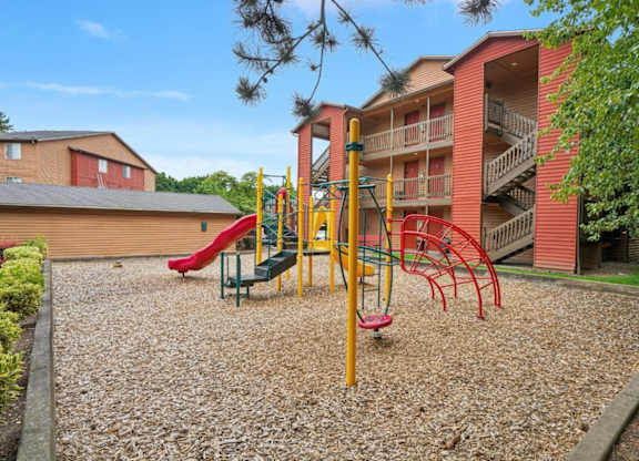 A playground with a red slide and a yellow structure.