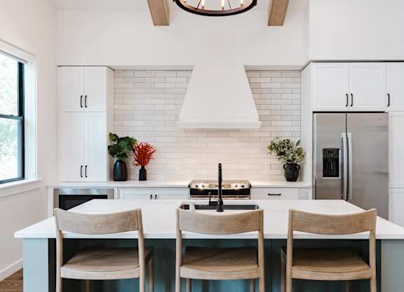 A kitchen with a white countertop and a white backsplash.
