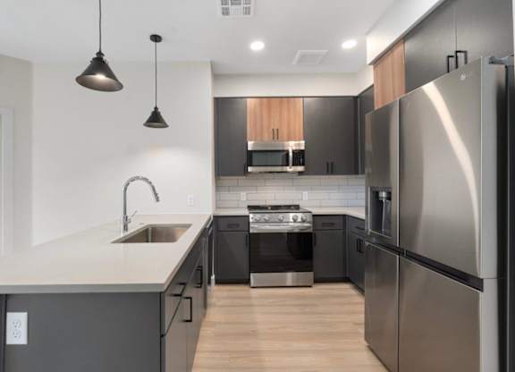 a renovated kitchen with a blue island and a stainless steel refrigerator