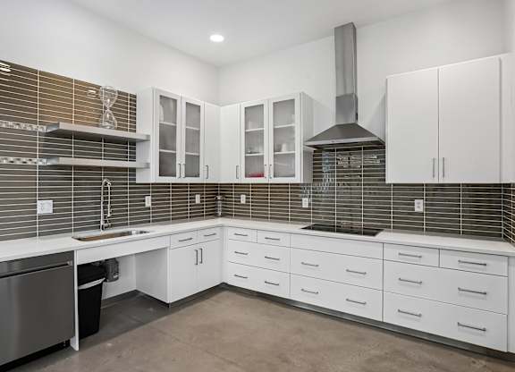 A modern kitchen with white cabinets and a stainless steel dishwasher.