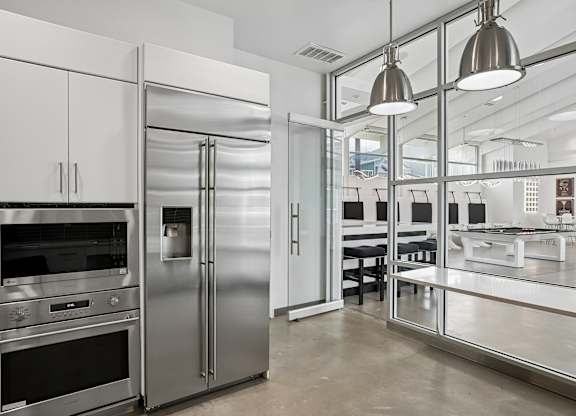 A modern kitchen with stainless steel appliances and white cabinetry.
