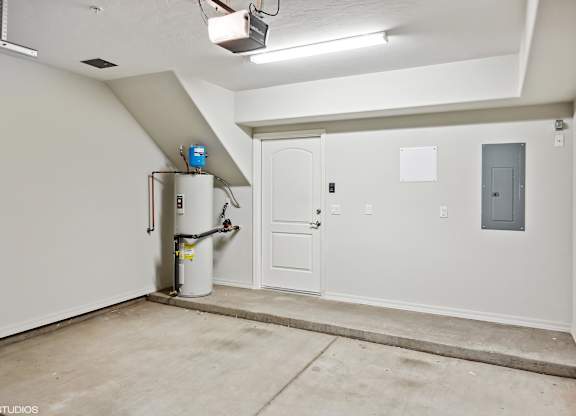 A room with a white door, a white wall, and a white ceiling.