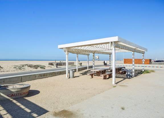 A white beach pavilion with a caution tape on the ground.