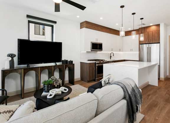 A modern living room with a grey sofa and a black television.
