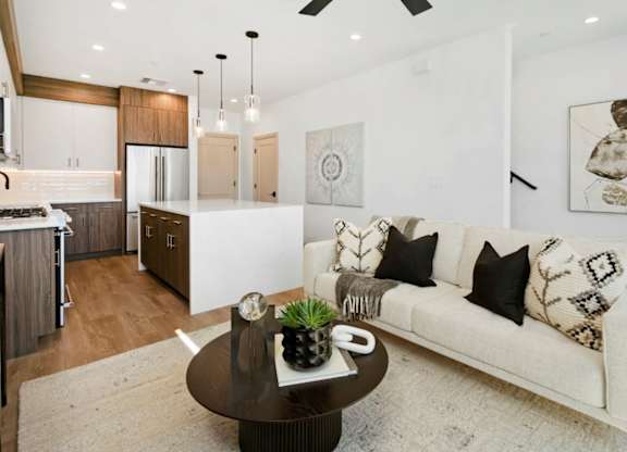 A modern living room with a white couch and a coffee table with a pineapple on it.