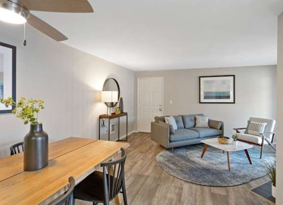 A living room with a grey couch and a wooden table.