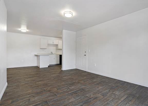 A room with wooden flooring and white walls.