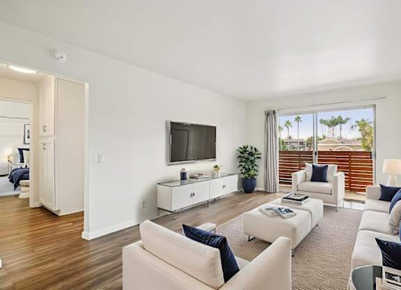A living room with white furniture and a flat screen TV.