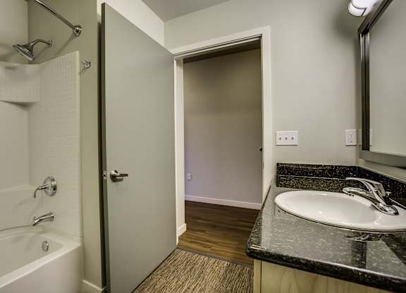A bathroom with a white tub and sink.
