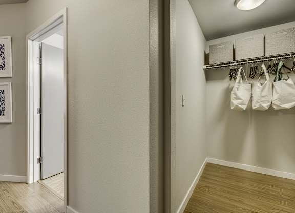 A hallway with a white door and a wall with two pictures on it.