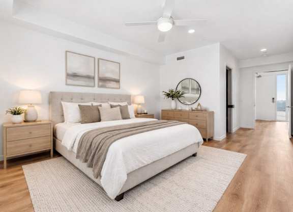 A bedroom with a large bed, a dresser, and a mirror.