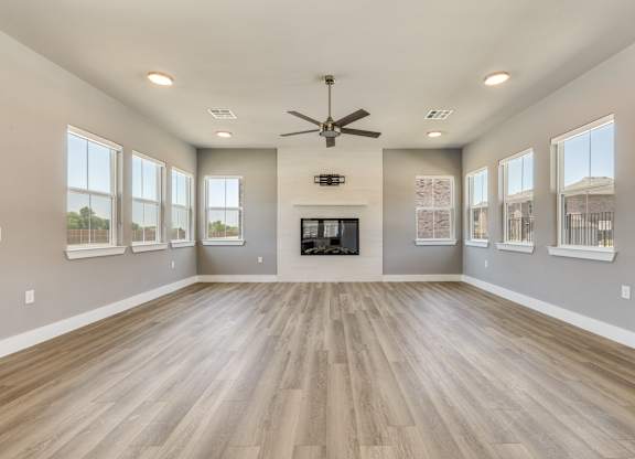 A spacious room with a fireplace and wood flooring.at Four Cedars, Gunter