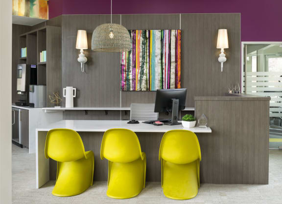 an office with purple walls and a desk with three yellow chairs