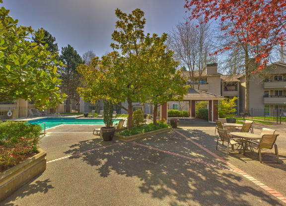 a courtyard with a swimming pool and trees and benches