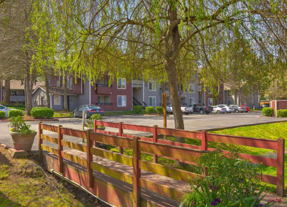 a park with a wooden fence in front of an apartment building