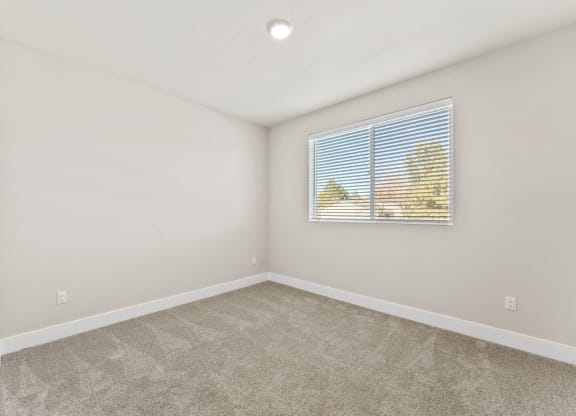 an empty room with a window and a mural on the wall