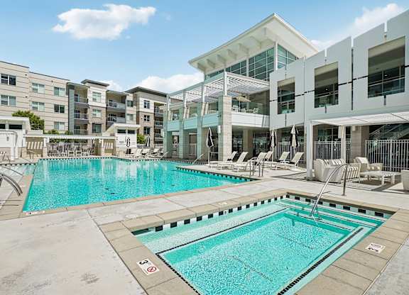 A swimming pool in front of apartment buildings.