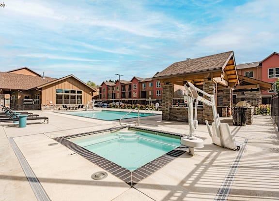 A large outdoor swimming pool with a slide and sun loungers.