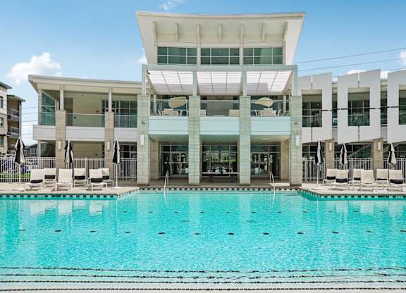 A large swimming pool in front of a modern building.