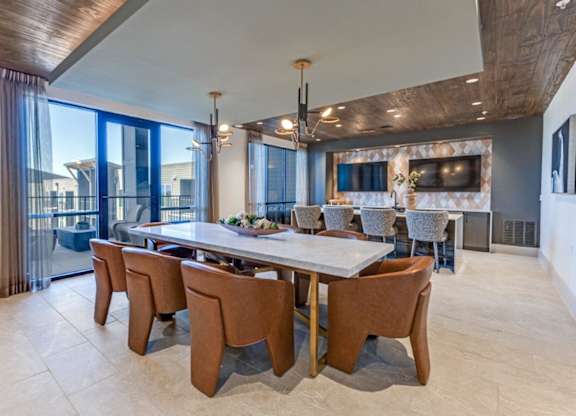 A modern dining room with a large table and chairs.