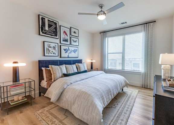 A bedroom with a large bed and a ceiling fan.