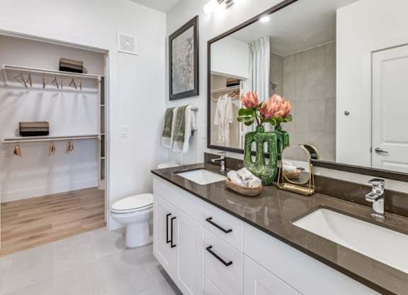 A bathroom with a white toilet, a sink, and a mirror.