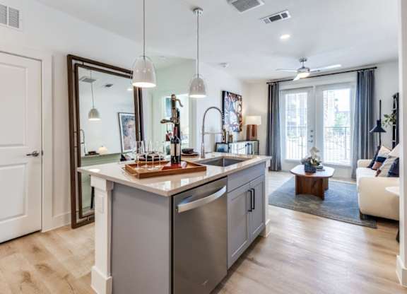 A modern kitchen with a wooden island and stainless steel appliances.