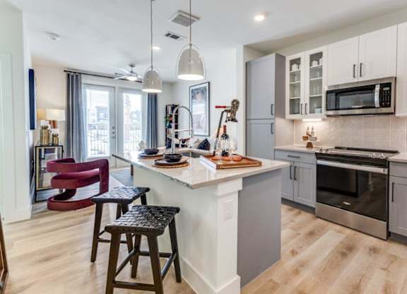 A modern kitchen with a bar stool and a countertop.