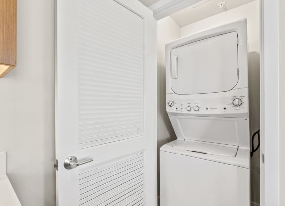 a white washer and dryer in a closet next to a white door