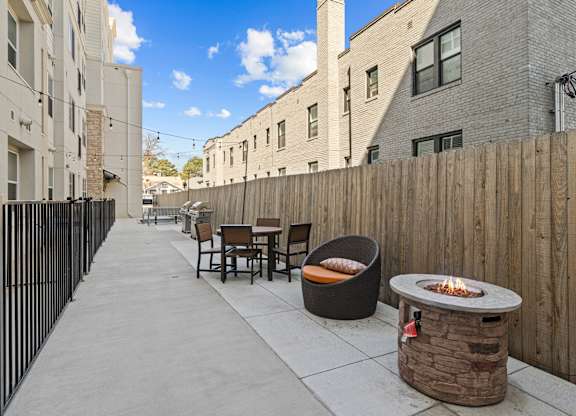 a patio with tables and chairs and a fire pit at Alton Jefferson Park, Denver, CO 80211