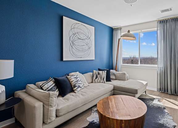 a living room with a blue wall and a couch and a table at Alton Jefferson Park, Denver, 80211