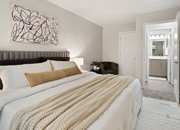 The Grove Apartments bedroom with large bed and nightstands and bathroom