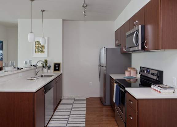 A kitchen with a refrigerator, microwave, and oven.
