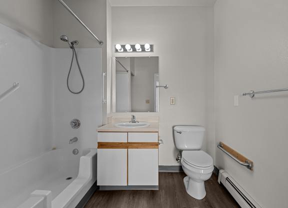 A white bathroom with a white toilet, sink, and bathtub.