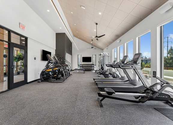 A gym with treadmills, elliptical machines, and other exercise equipment.