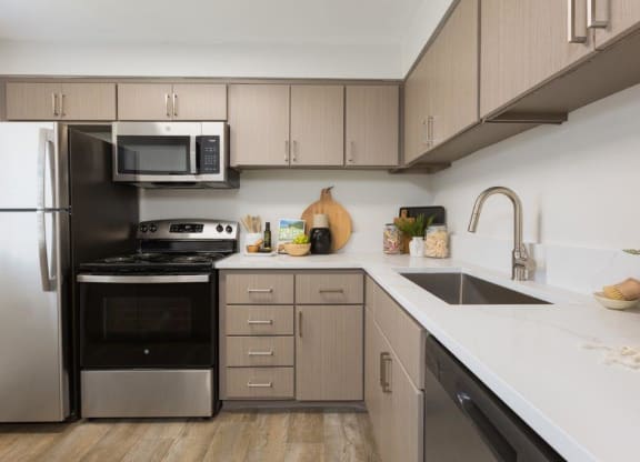 a kitchen with stainless steel appliances and white counter tops